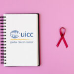 UICC logo on a notebook next to a pink ribbon