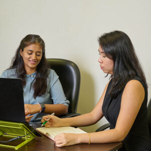 Two Global Lingo employees looking at a screen and working together