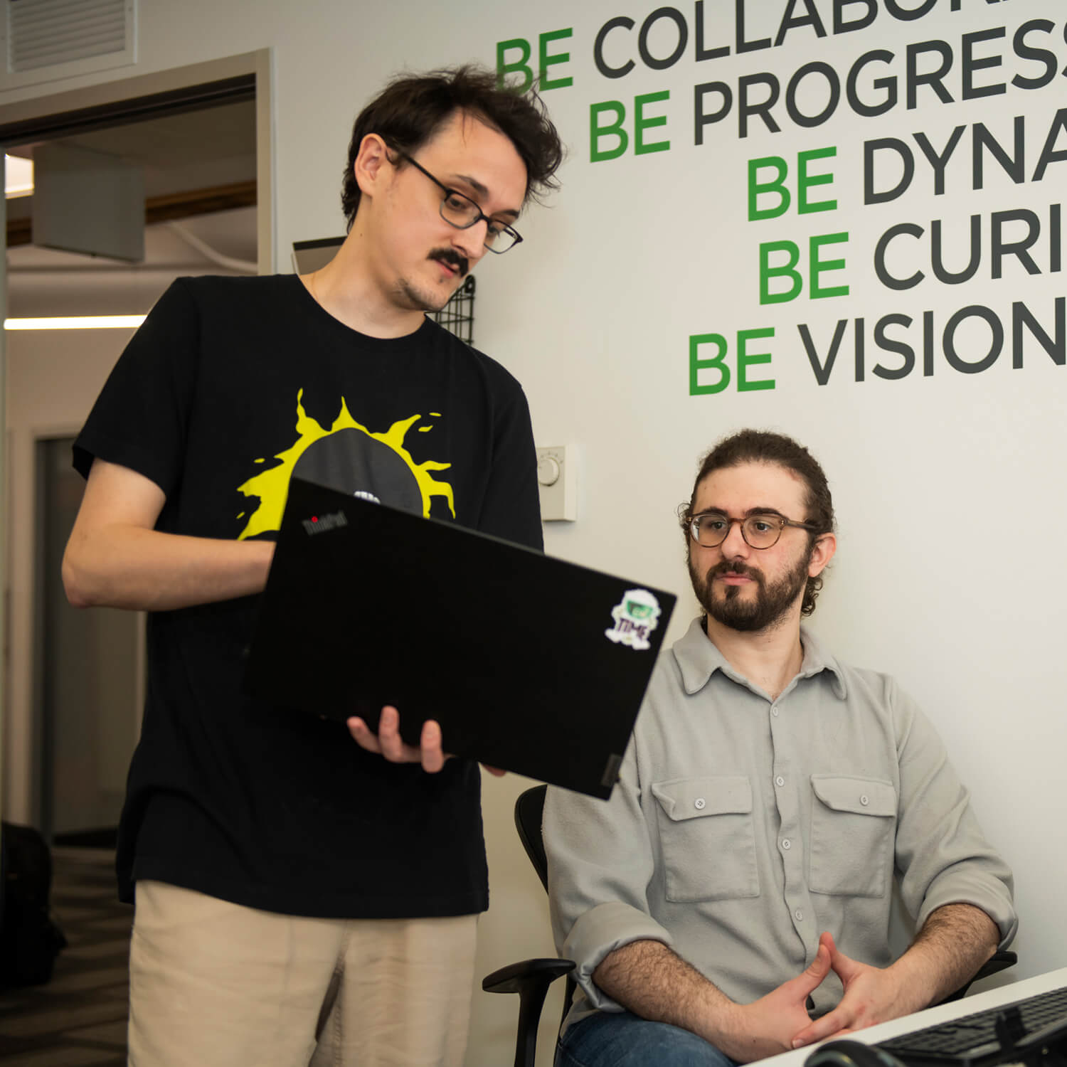 Two Global Lingo employees looking at a screen and working together