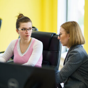 Two Global Lingo employees looking at a screen and working together