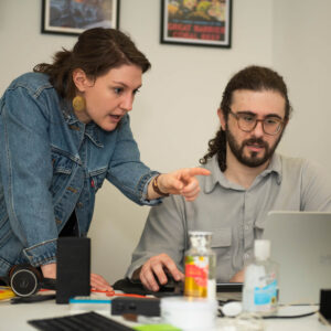 Two Global Lingo employees looking at a screen and working together