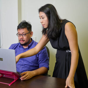 Two Global Lingo employees looking at a screen and working together