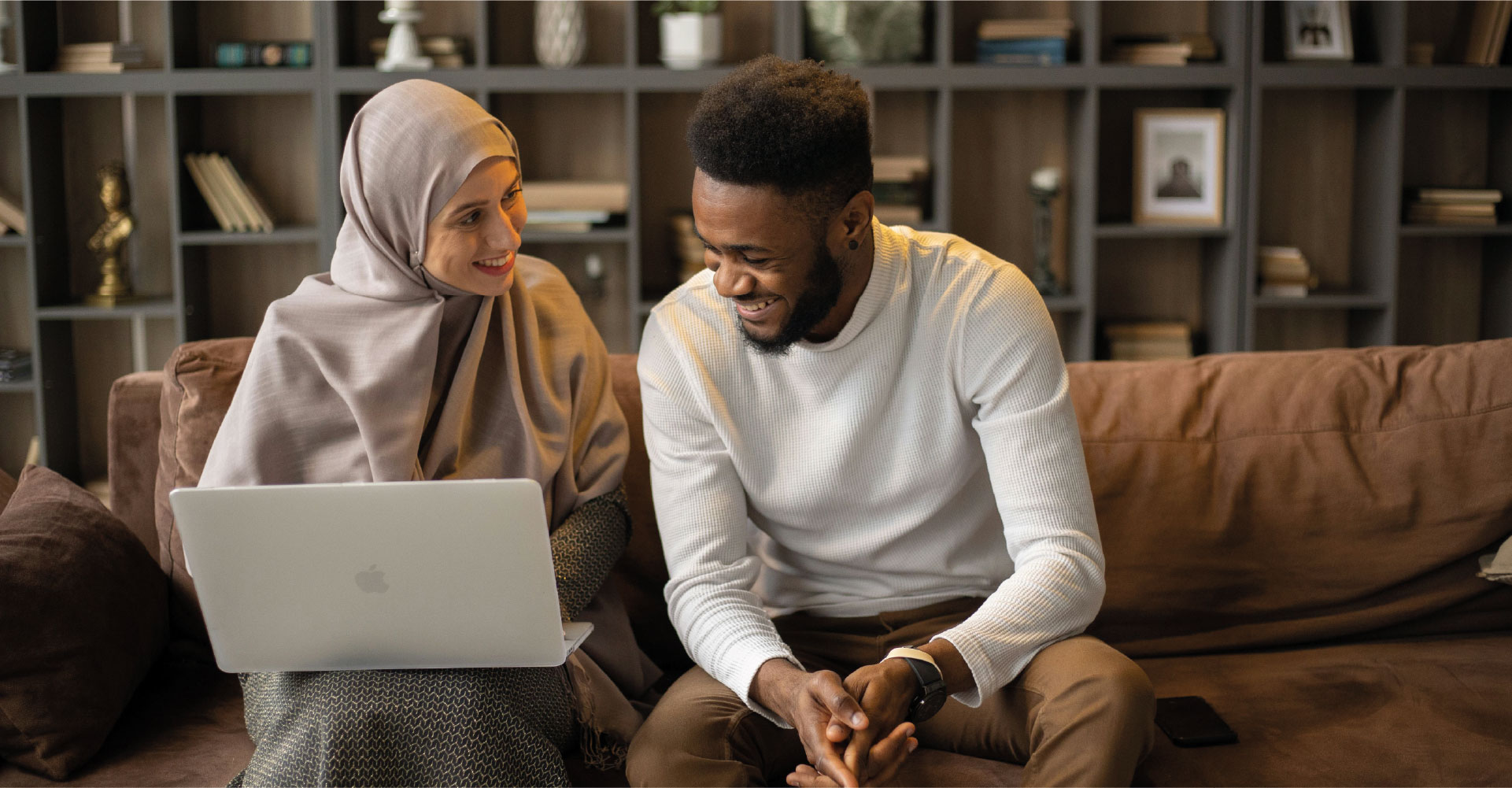 A man and a woman looking at research material on a laptop