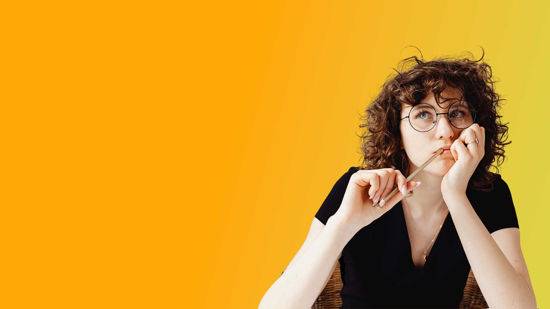 eLearning candidate contemplating with a pen in her mouth.
