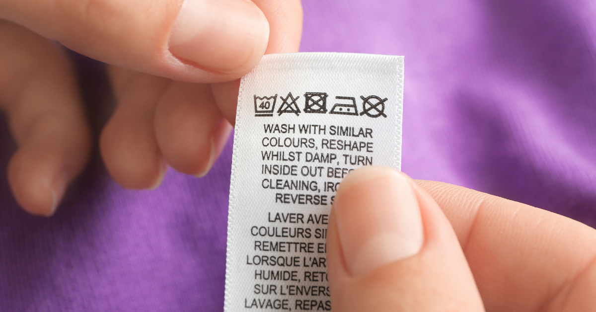Close-up of a clothing care label with washing instructions in multiple languages