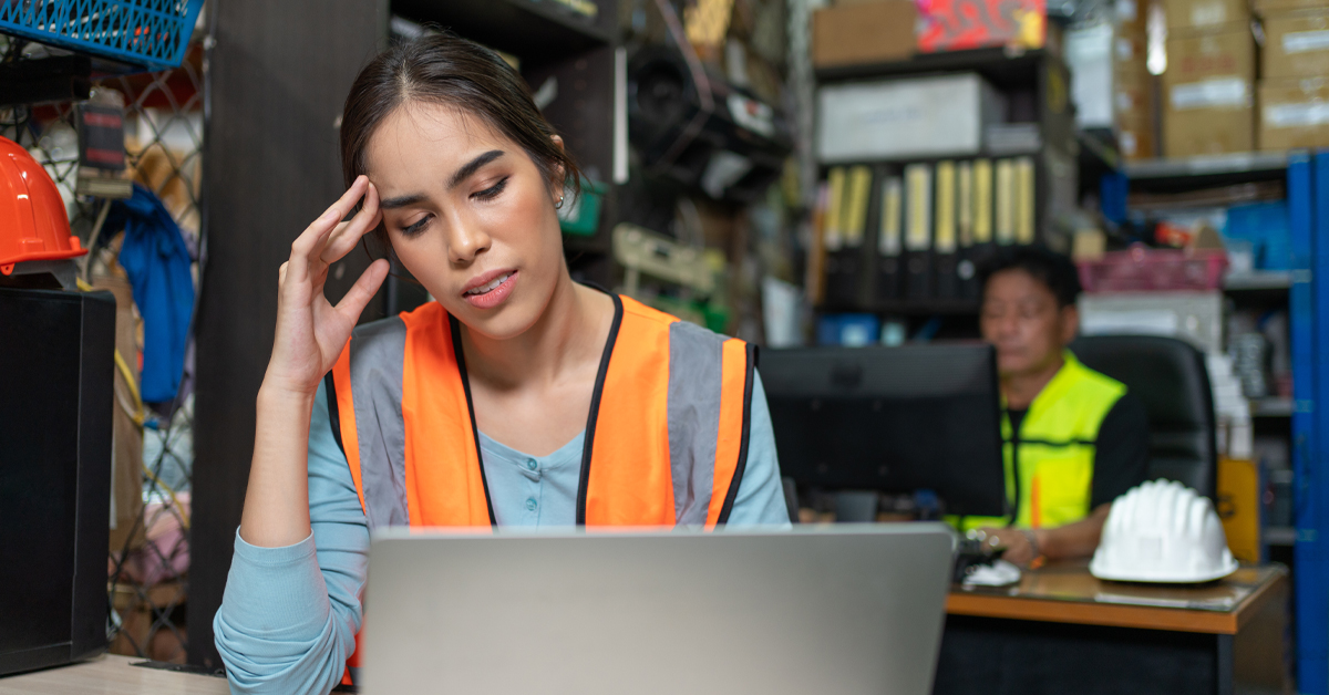 Retail warehouse employee reviewing training or compliance information on a laptop