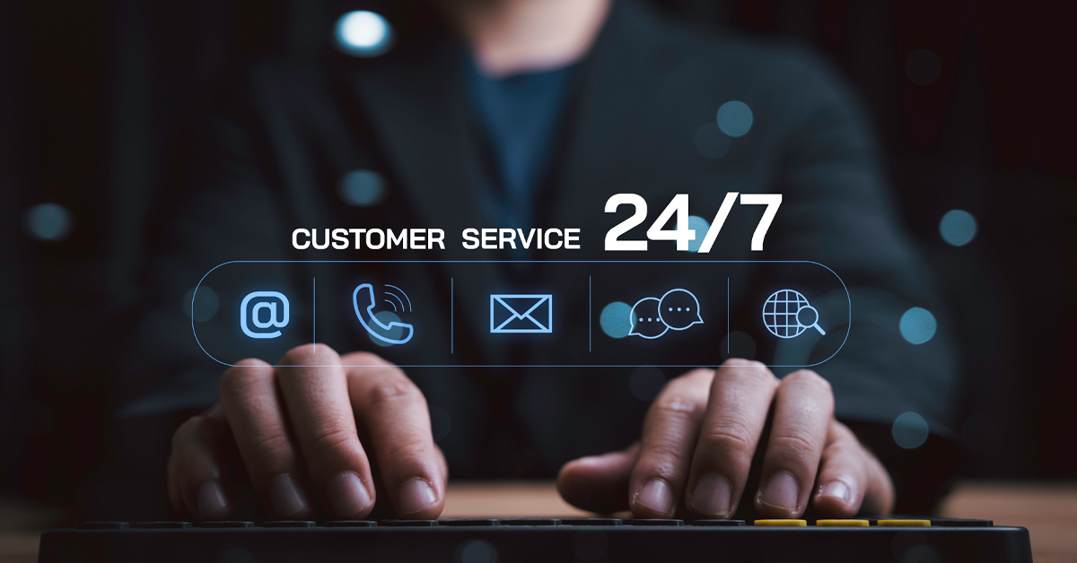 A person working at a keyboard with a digital overlay showing 24/7 customer service icons for email, phone, and global support
