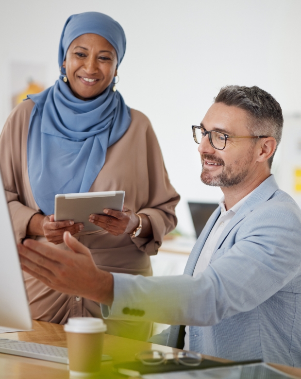 Two business professionals discussing a project at a desk, showcasing expert communication strategies. Arabic Language Services