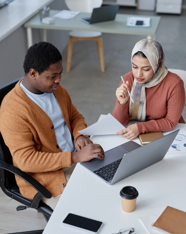Business team collaborating on a laptop project, illustrating Indonesian linguistic and business support