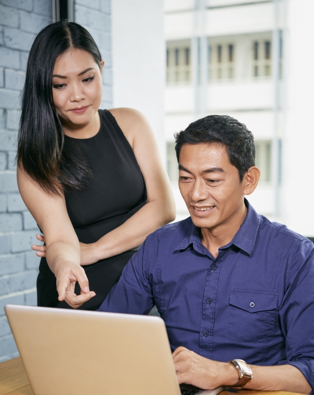 Business partners reviewing content on a tablet, symbolizing Lao linguistic and business services