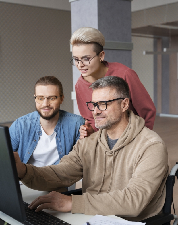 A group of professional colleagues working together at a computer station for Czech language projects