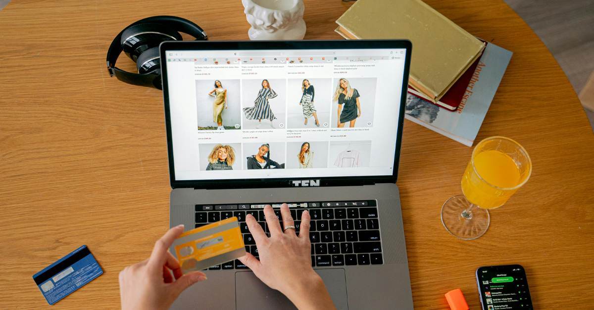 Person shopping for clothing online using a laptop and credit card, illustrating omnichannel retail trends in 2026