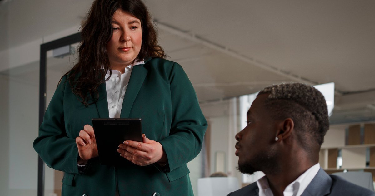 A senior professional reviewing AI-generated output on a tablet with a colleague, illustrating the importance of human oversight when using AI tools in a legal setting