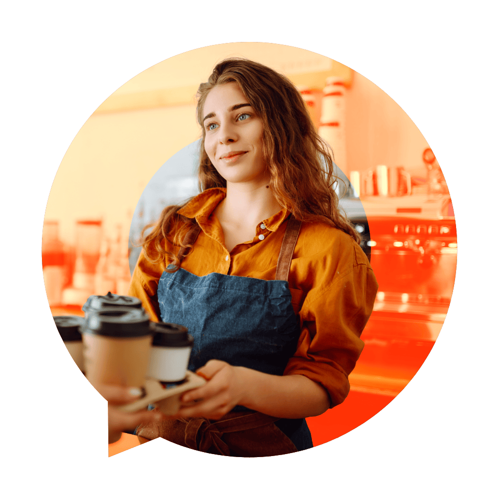 barista in an apron holding takeaway coffee cups in a warm cafe setting