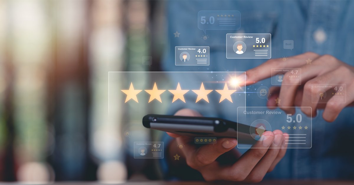 A person holds a smartphone displaying five-star customer reviews and ratings, highlighting how guest reviews influence AI discoverability as part of current trends in travel and tourism.
