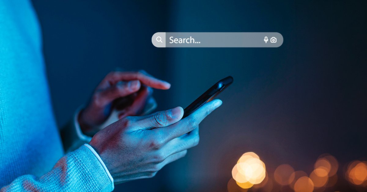 A person searches on a smartphone at night, reflecting how AI-powered search has fundamentally changed how travelers discover brands, a defining shift in current trends in travel and tourism.
