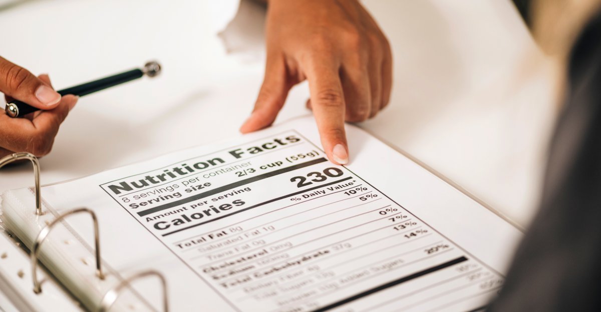 Person pointing at a Nutrition Facts panel, illustrating US food and beverage packaging design requirements under FDA 21 CFR Part 101