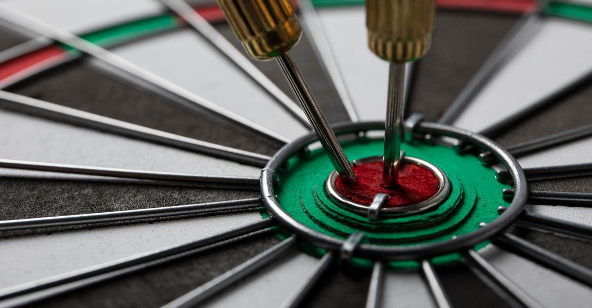 Two darts hitting the bullseye of a dartboard, representing precision and accuracy