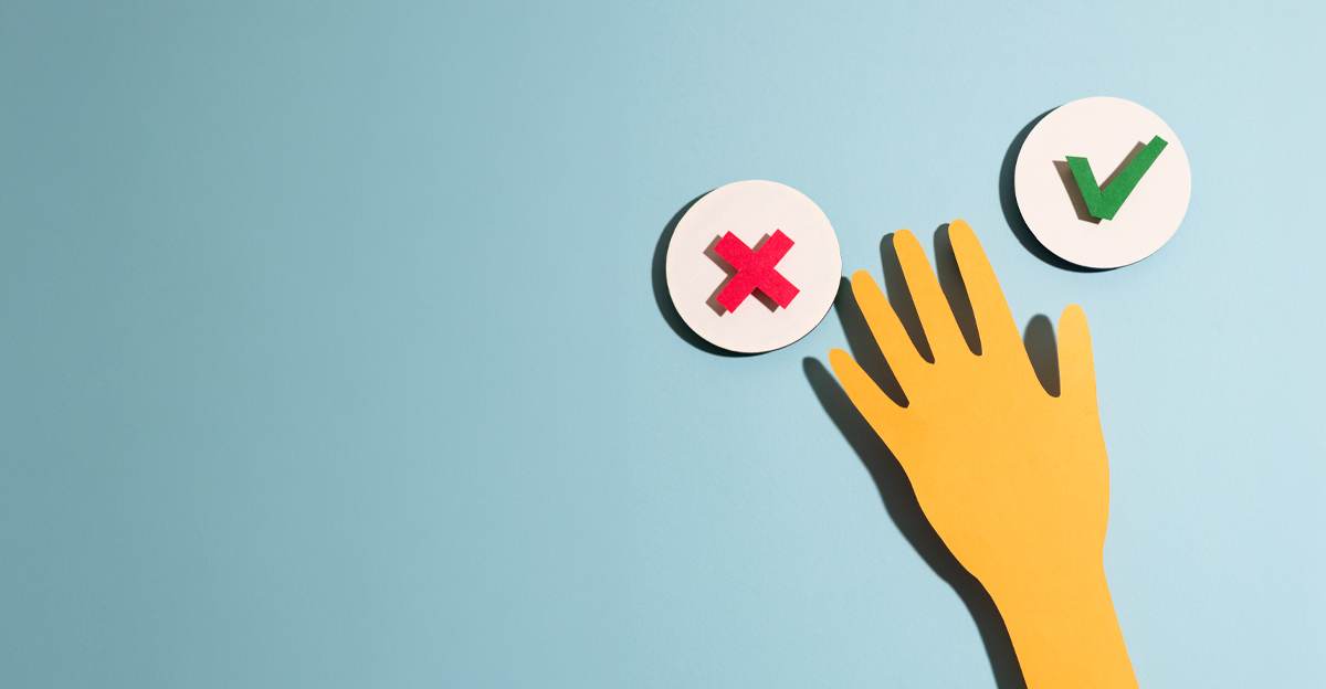A paper cutout hand reaching toward an X and a checkmark, weighing two options