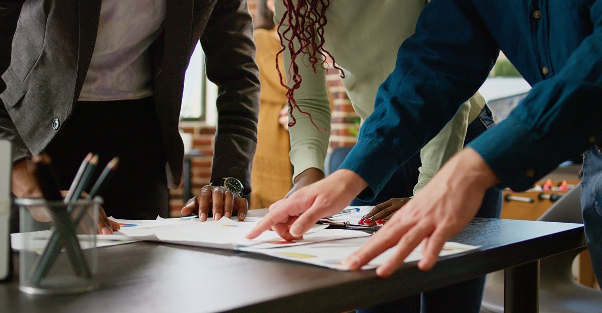 A team reviewing colorful charts and data spread across a table