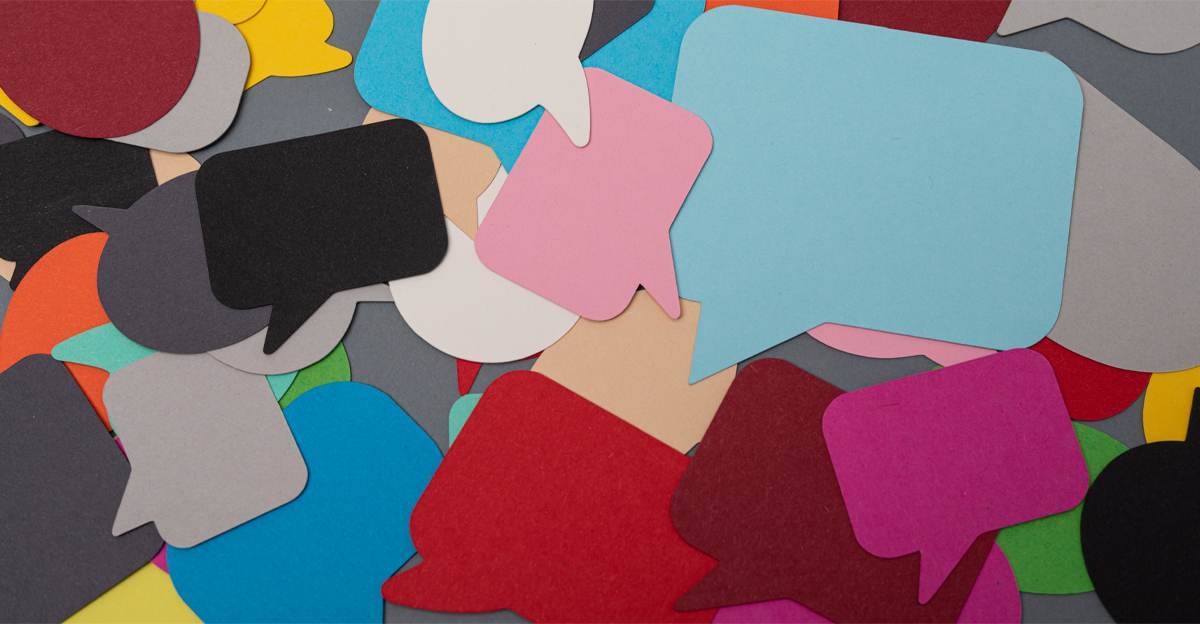 A colorful pile of overlapping paper speech bubbles in various shapes and colors