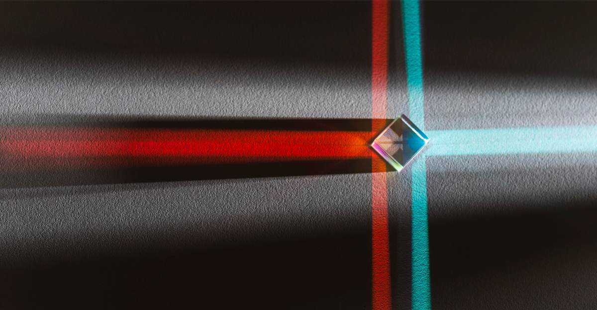 A glass prism splitting a beam of light into red and blue paths, marking where translation ends and localization begins